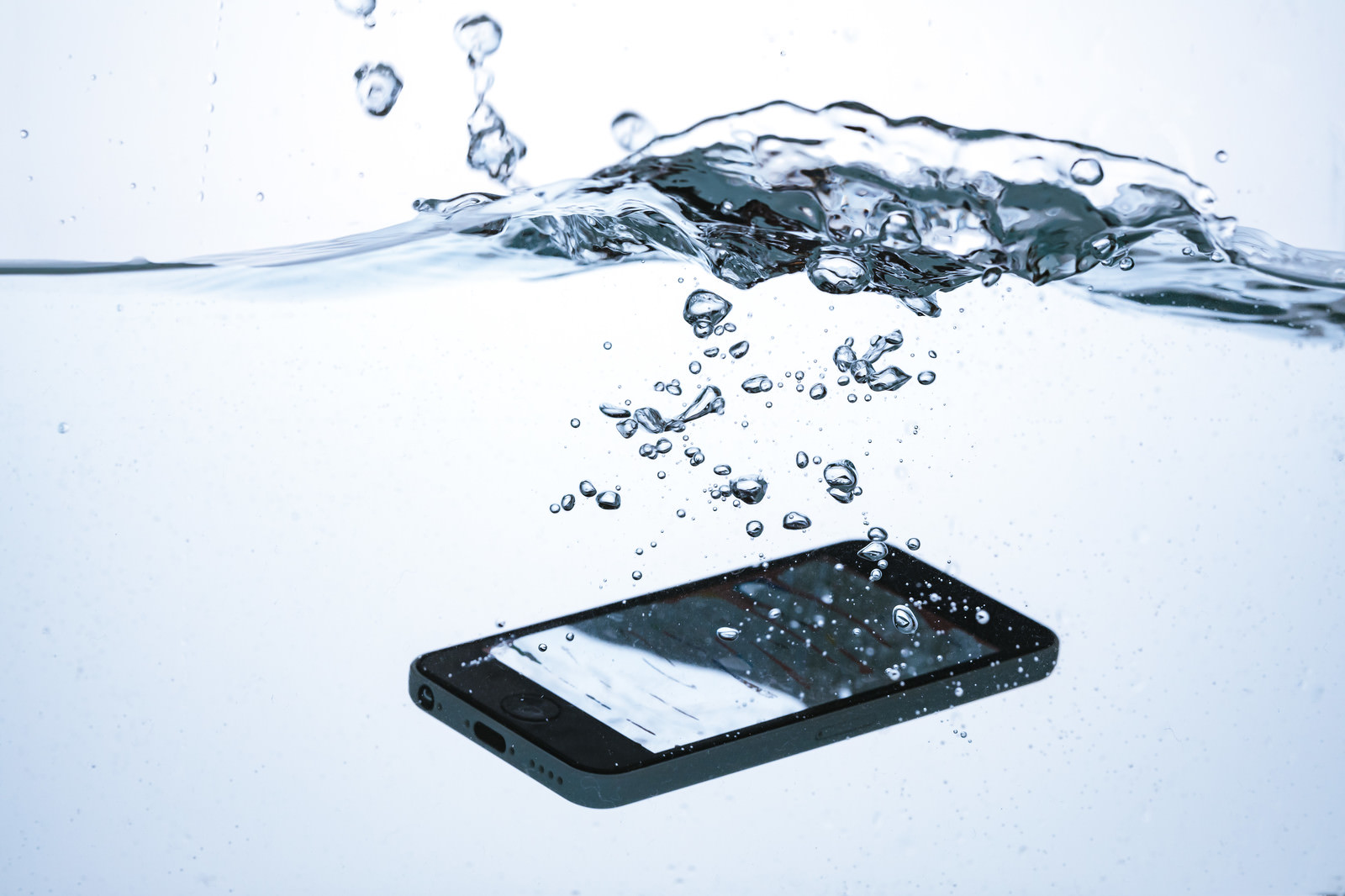 「スマートフォンが水没する瞬間 | フリー素材のぱくたそ」の写真