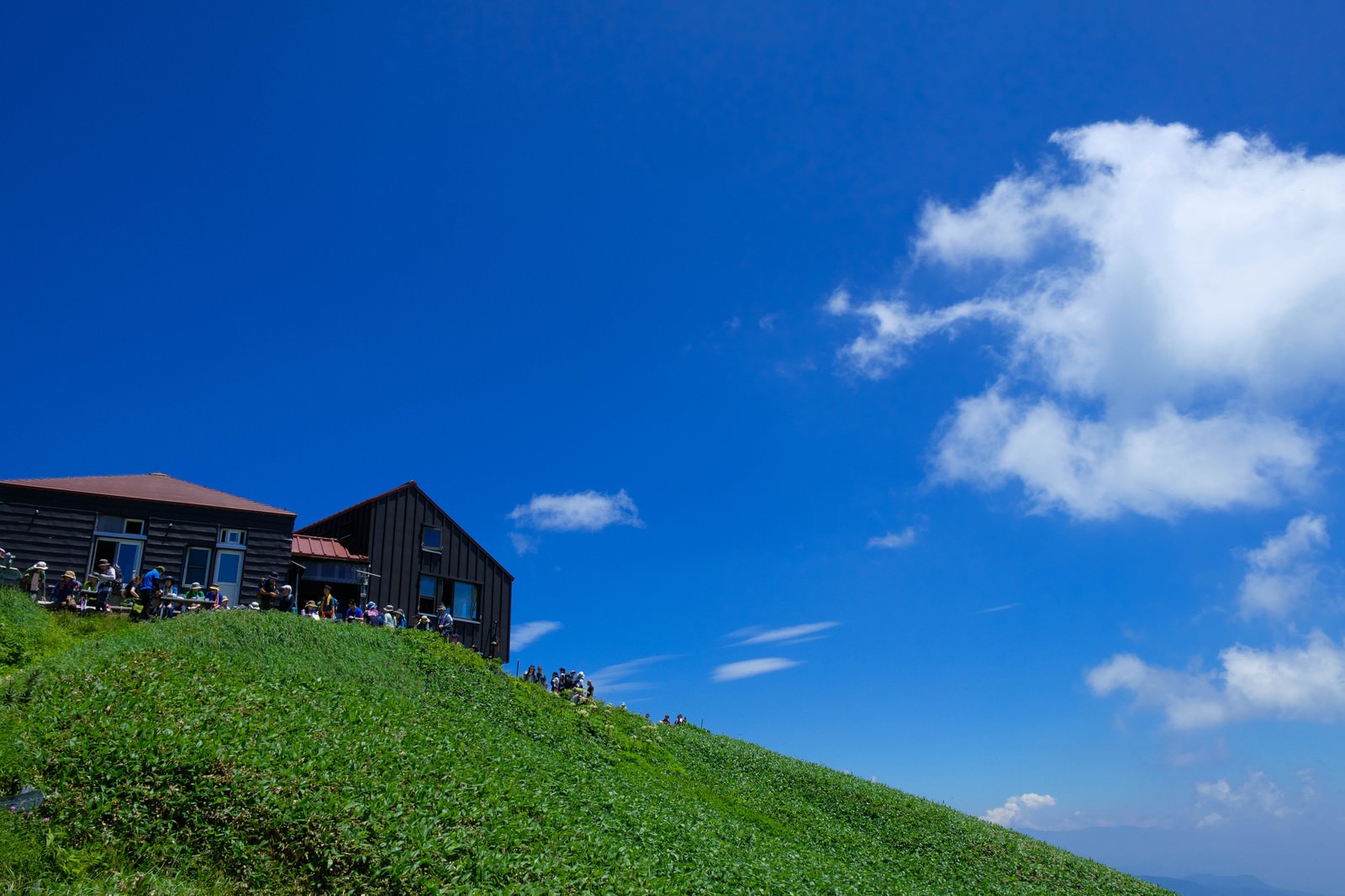 「山小屋で休憩する登山者達 | ぱくたそフリー素材」の写真