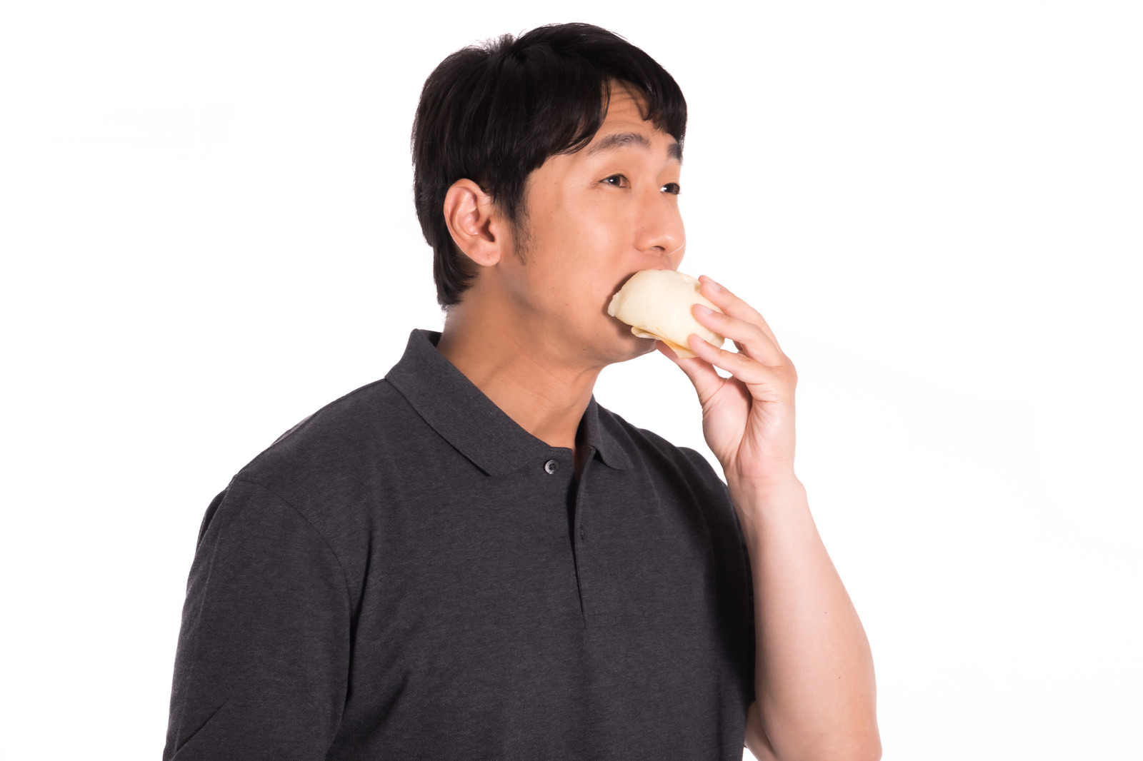「片手で豚まんを食べる男性 | フリー素材のぱくたそ」の写真［モデル：大川竜弥］
