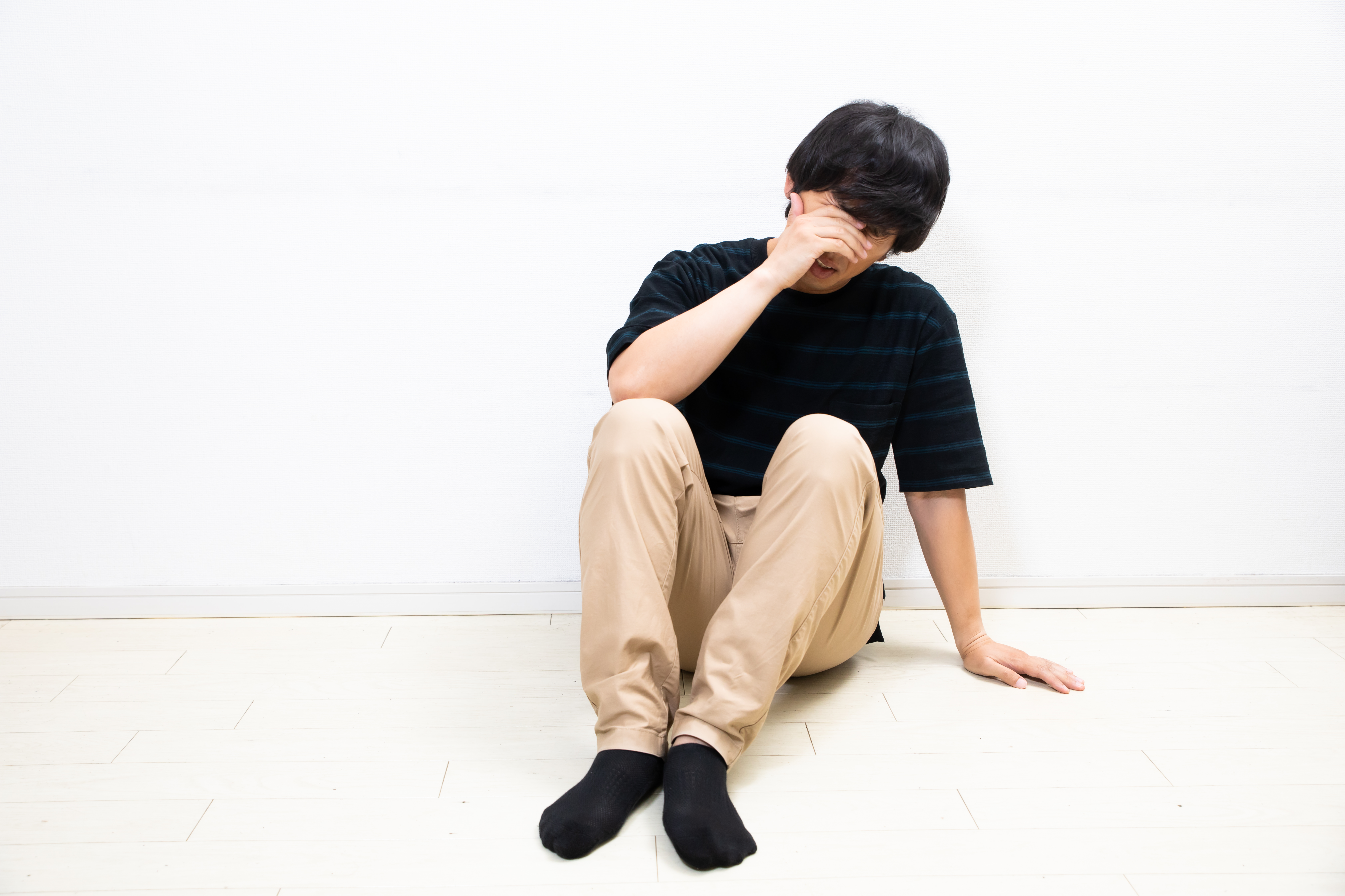 顔を覆い落ち込む男性の写真素材 ぱくたそ