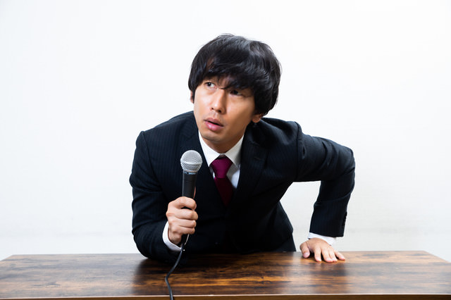 事実と違うことを指摘されて感情的になる広報担当の写真