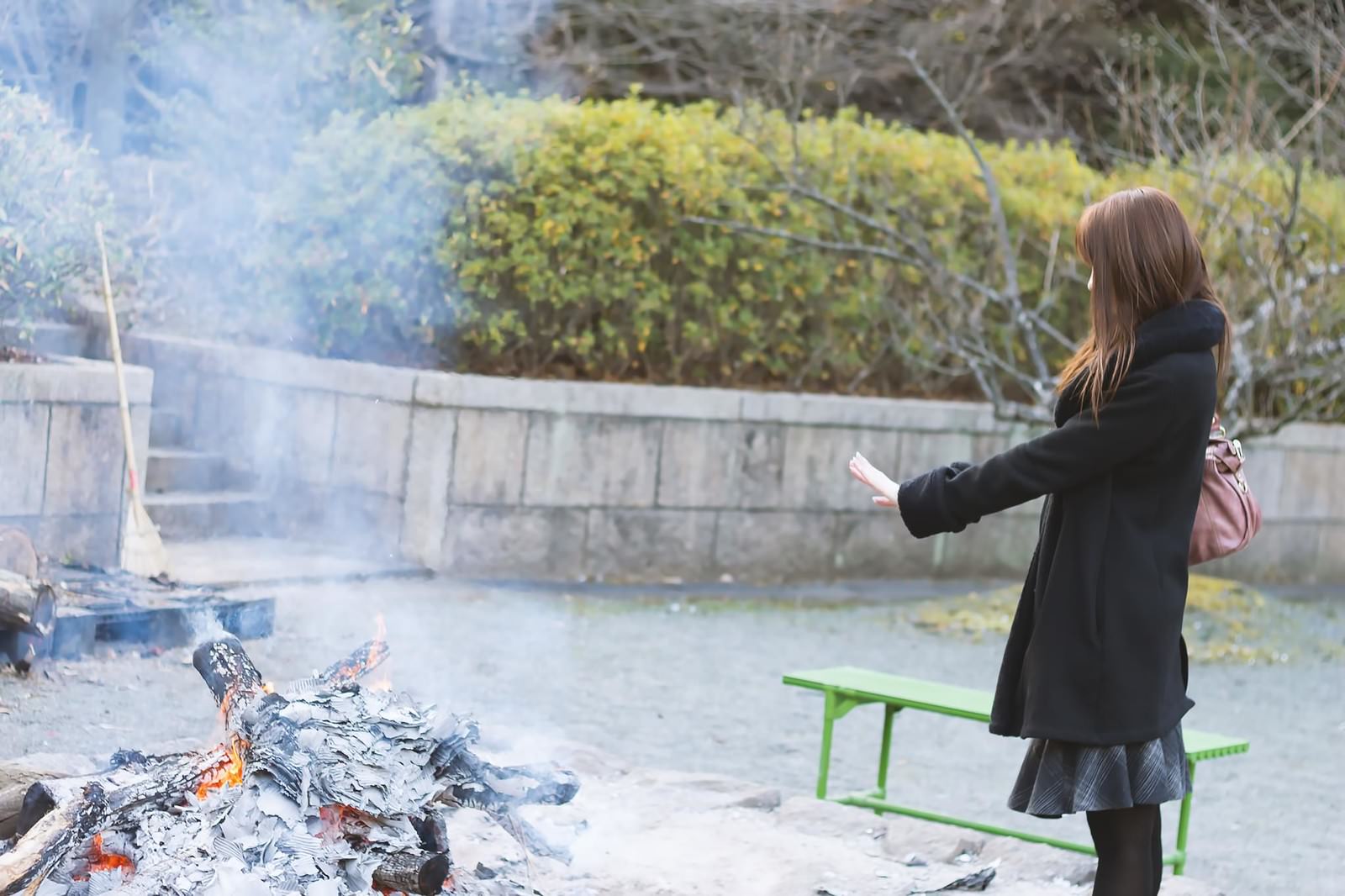 「焚火で温まる女性焚火で温まる女性」のフリー写真素材