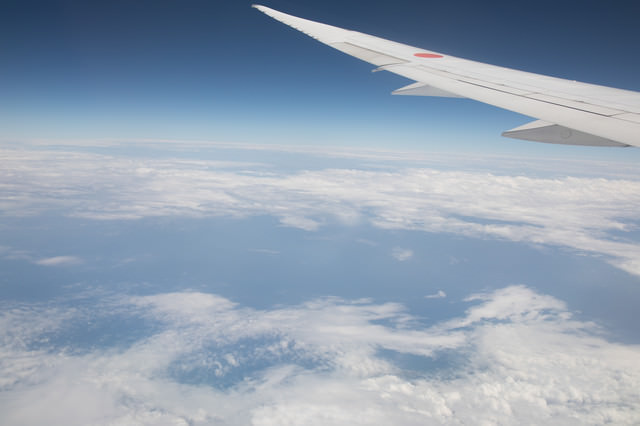 旅客機の翼と上空から見える景色