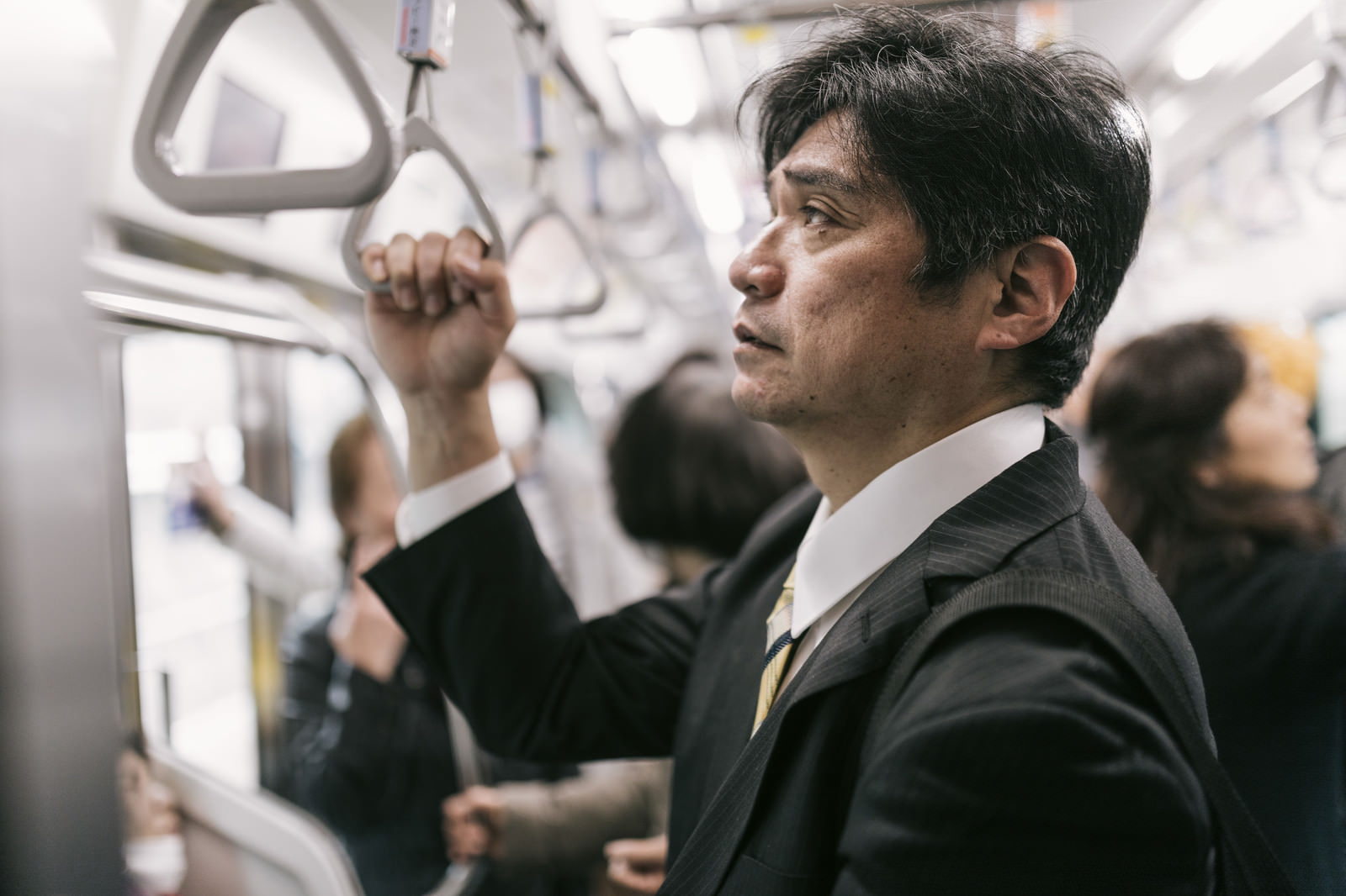 「単身赴任で満員電車に揺られて通勤するお父さん | フリー素材のぱくたそ」の写真［モデル：よたか］