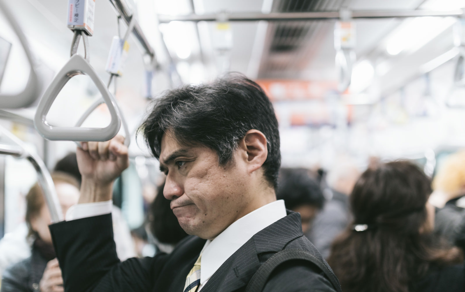 「電車内の迷惑行為を見て思わずイラッとくる中年の男性」の写真［モデル：よたか］