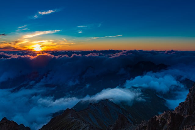 「槍ヶ岳山頂から見下ろす夕暮れの北アルプスの山々」のフリー写真素材