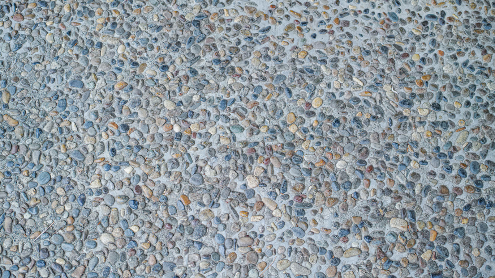 「色々な小石が埋め込まれた壁（テクスチャ） | フリー素材のぱくたそ」の写真