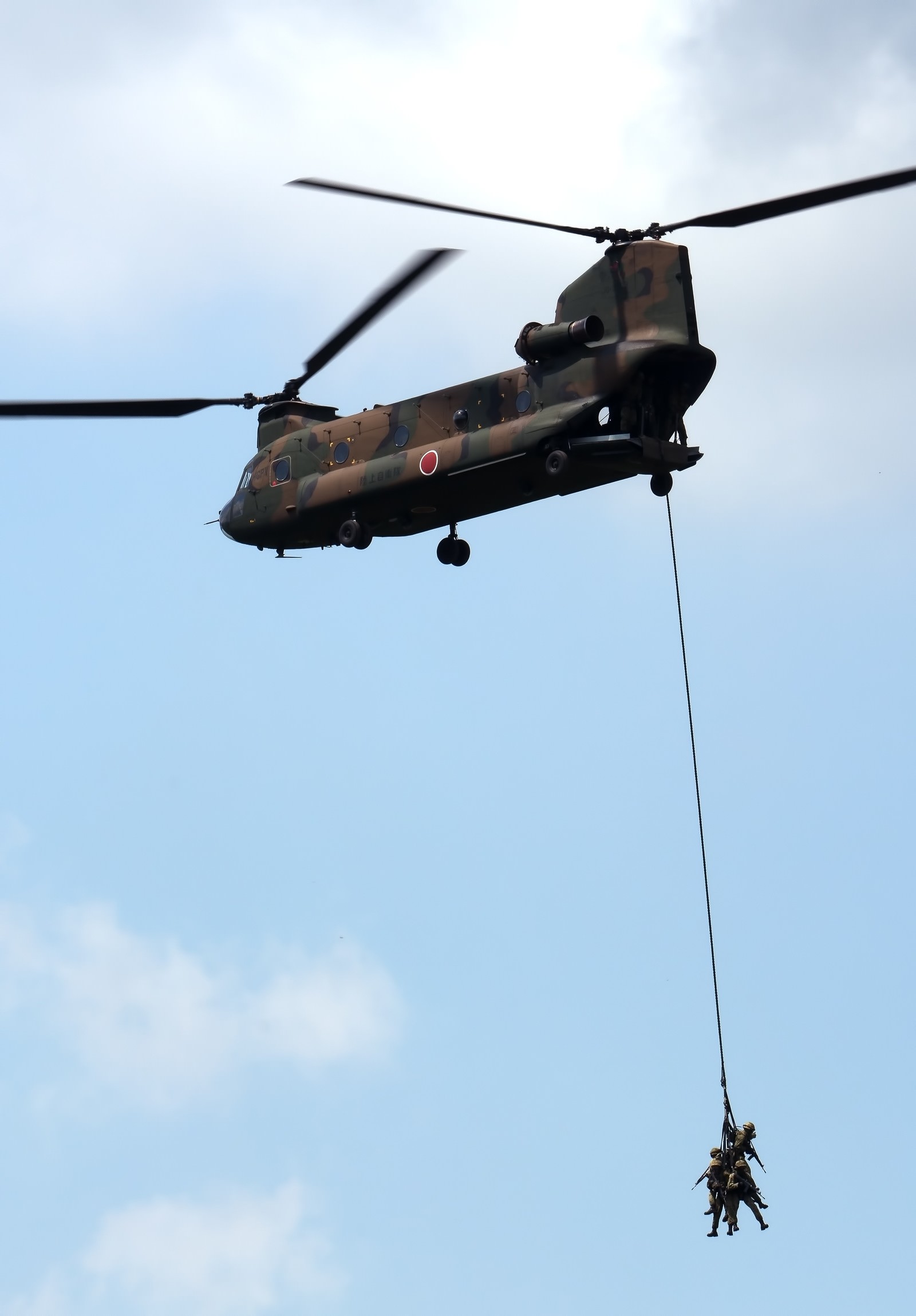 周囲を警戒しながら、CH-47に吊り下げられ撤収する隊員。の無料写真