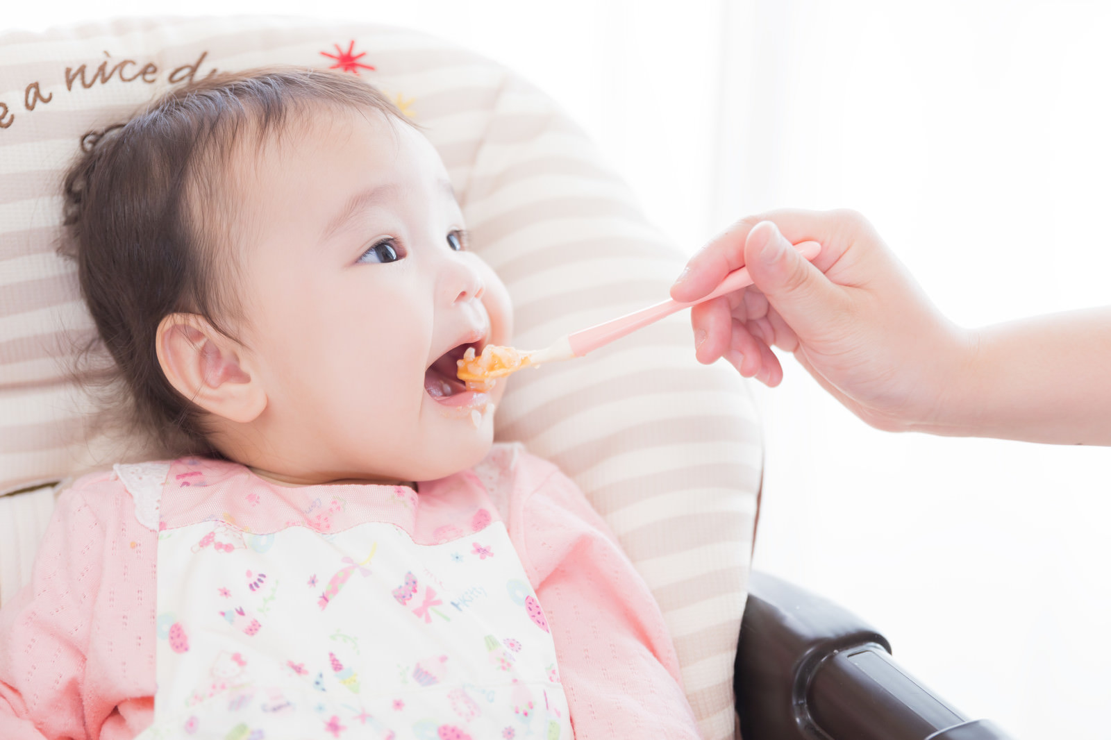 「大きなお口をあけて離乳食をあーん」の写真［モデル：めぐな］