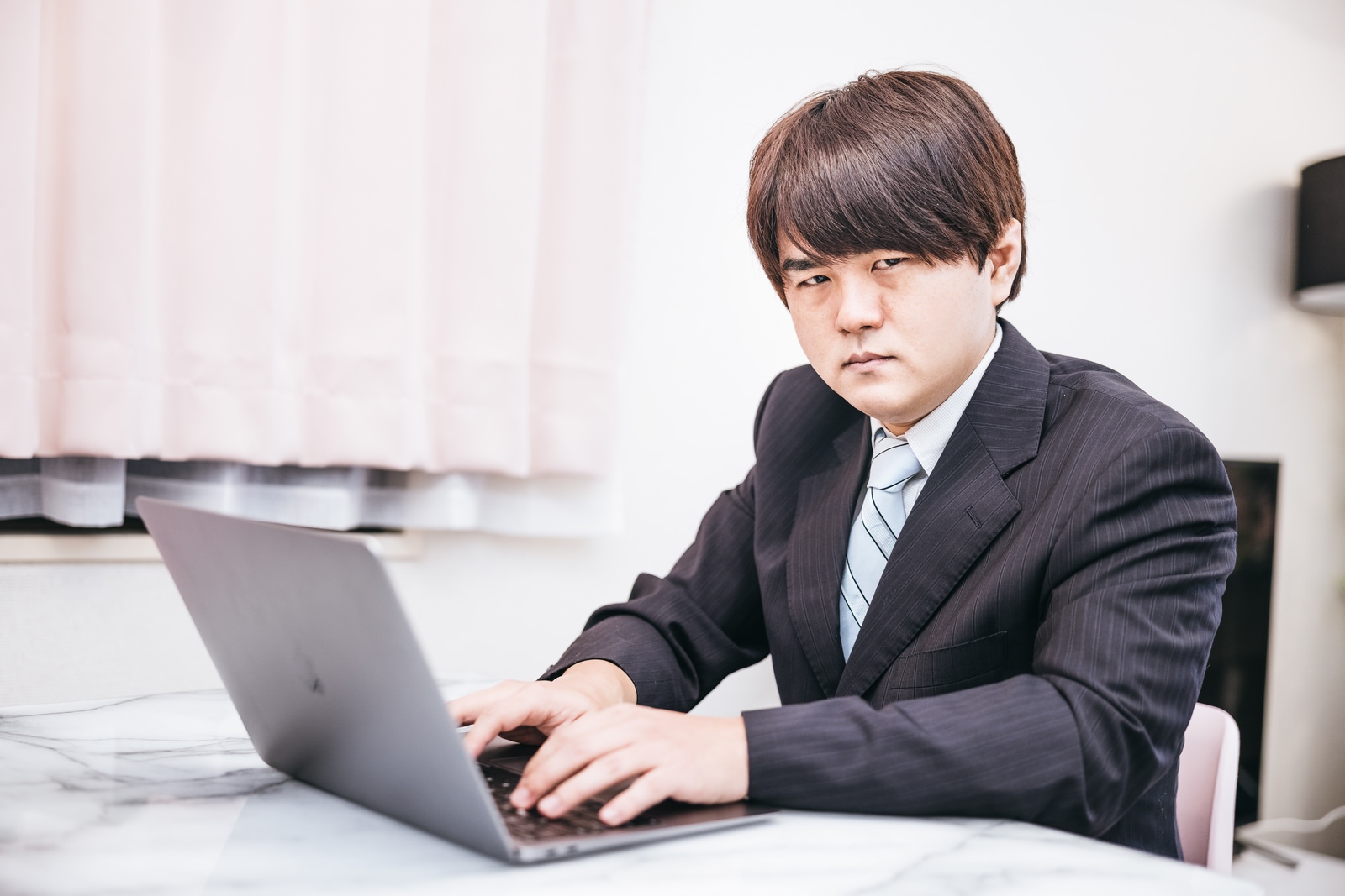 「スーツ姿で在宅ワークする男性 | フリー素材のぱくたそ」の写真［モデル：はしも。］