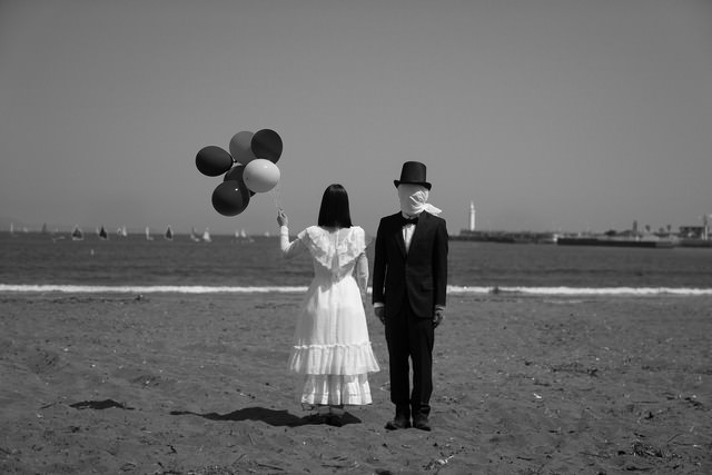 ふわふわとどこかへ飛んでいってしまいそうな女性と見守る男の写真