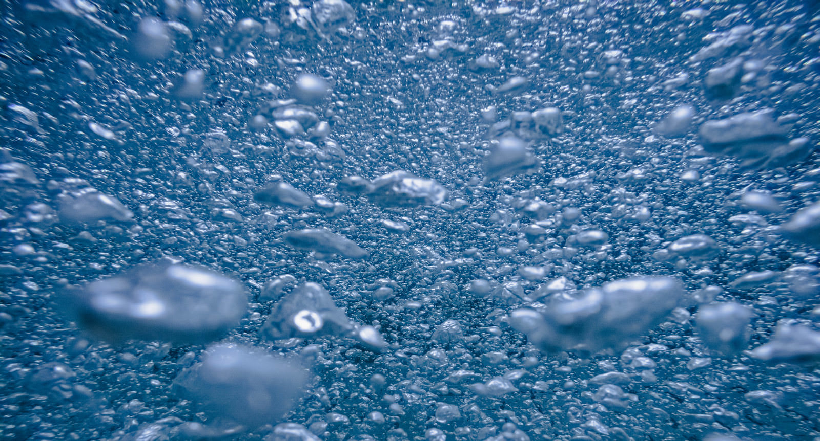 「水中に浮かぶ無数の泡 | フリー素材のぱくたそ」の写真