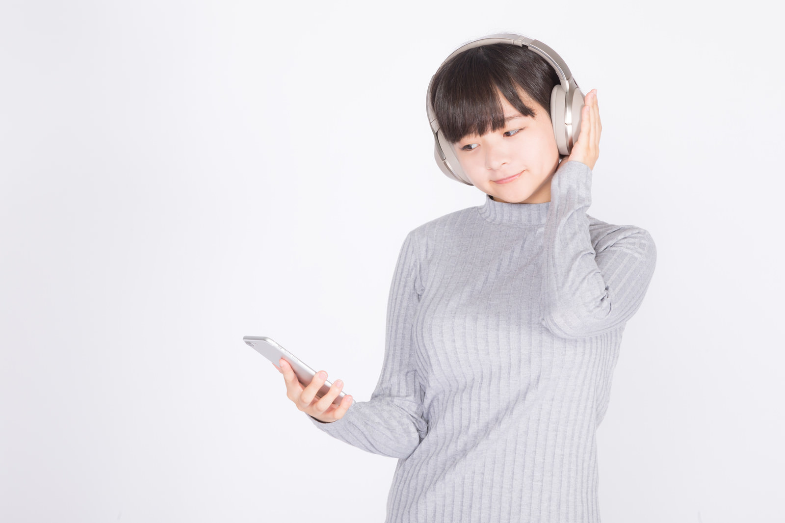 「ワイヤレスヘッドホンで音楽を楽しむ若い女性」［モデル：千歳］