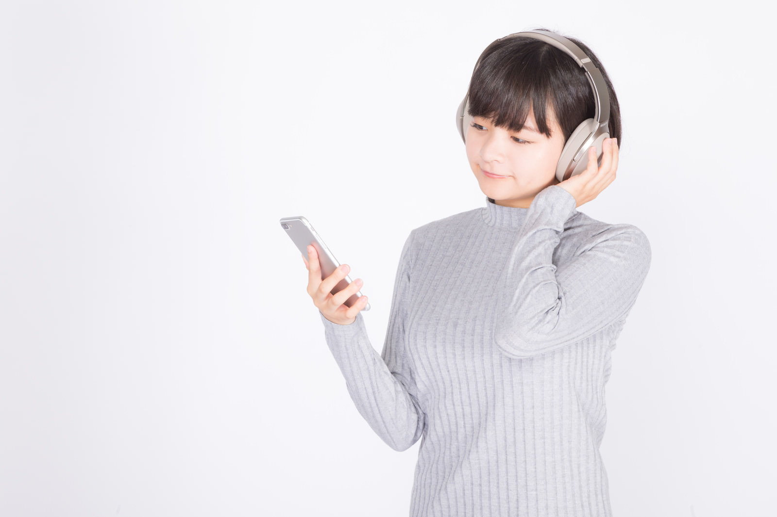 「スマホで音楽を楽しむ女性」の写真［モデル：千歳］