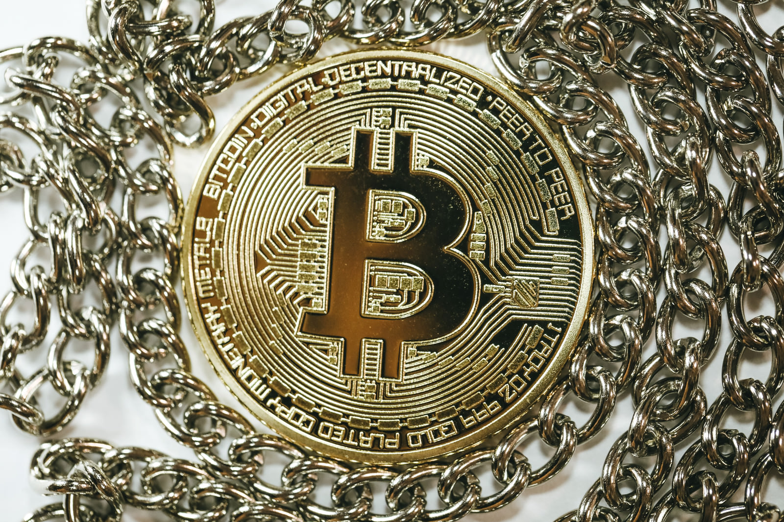 「チェーンの中心にあるビットコイン(仮想通貨)」の写真