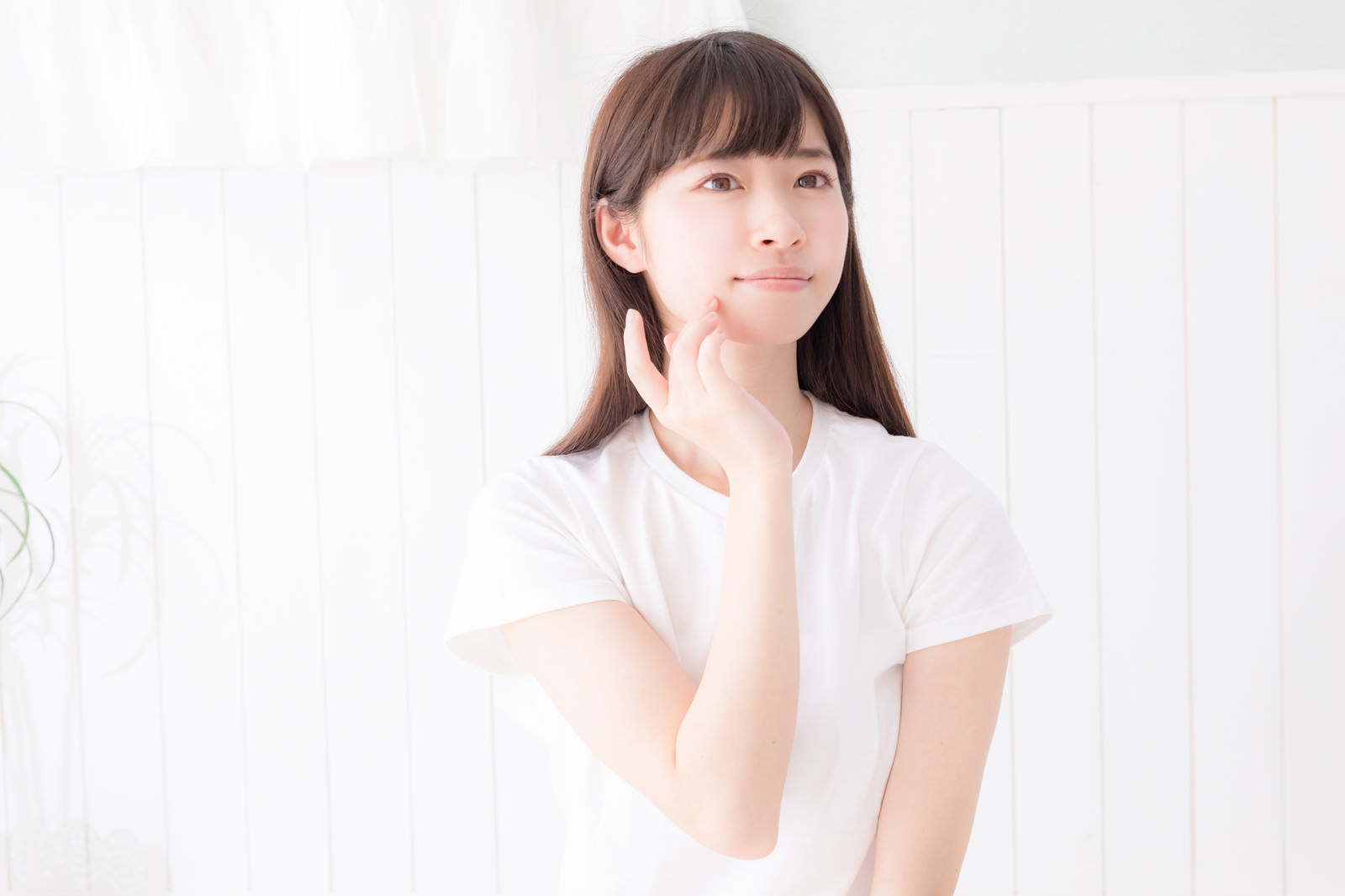 「肌の弾力を指で感じるスキンケア中の女性」の写真［モデル：川子芹菜］