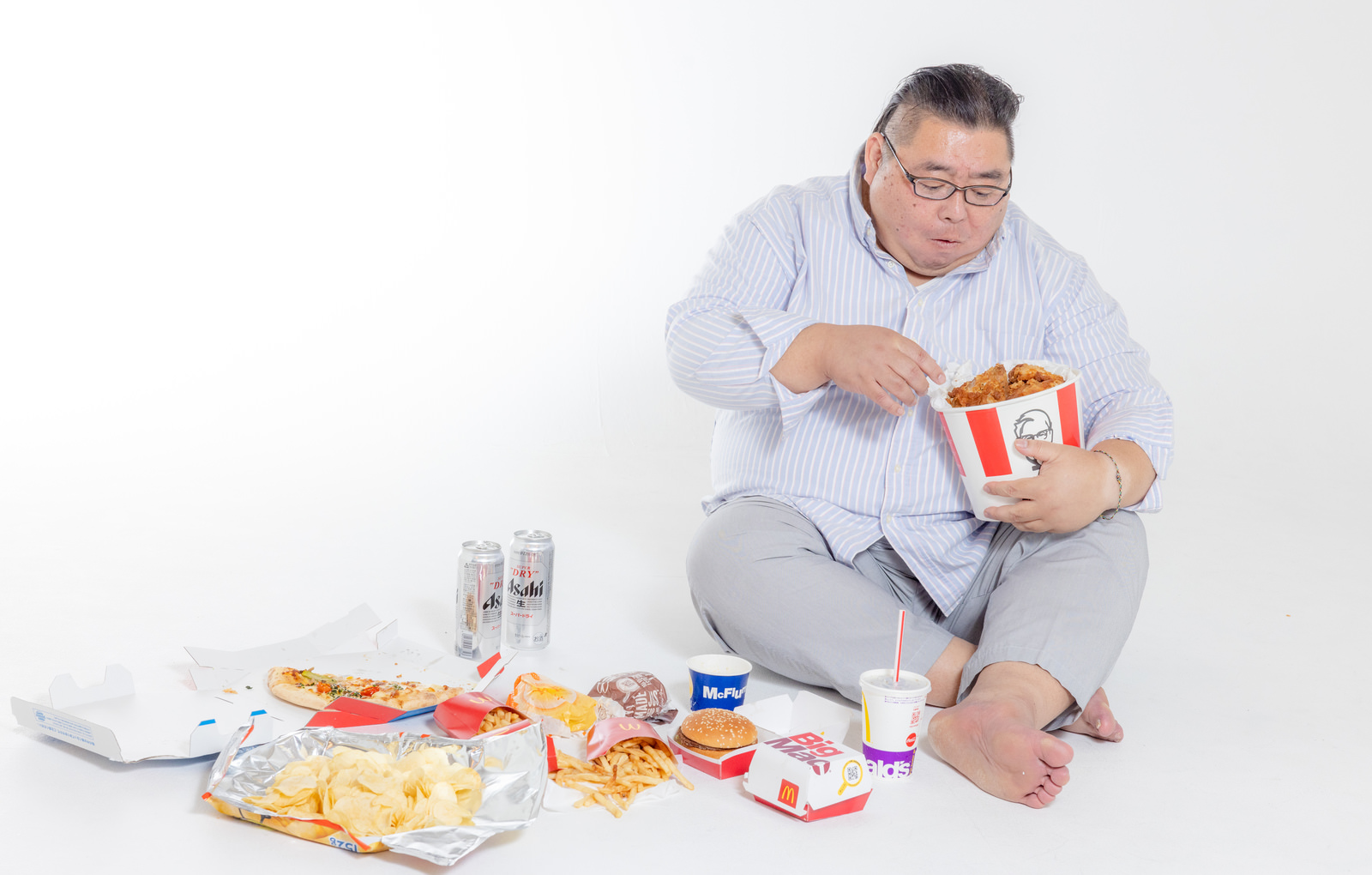 「ケンタを食べながら暴飲暴食男性 | フリー素材のぱくたそ」の写真［モデル：ダルマ親方］
