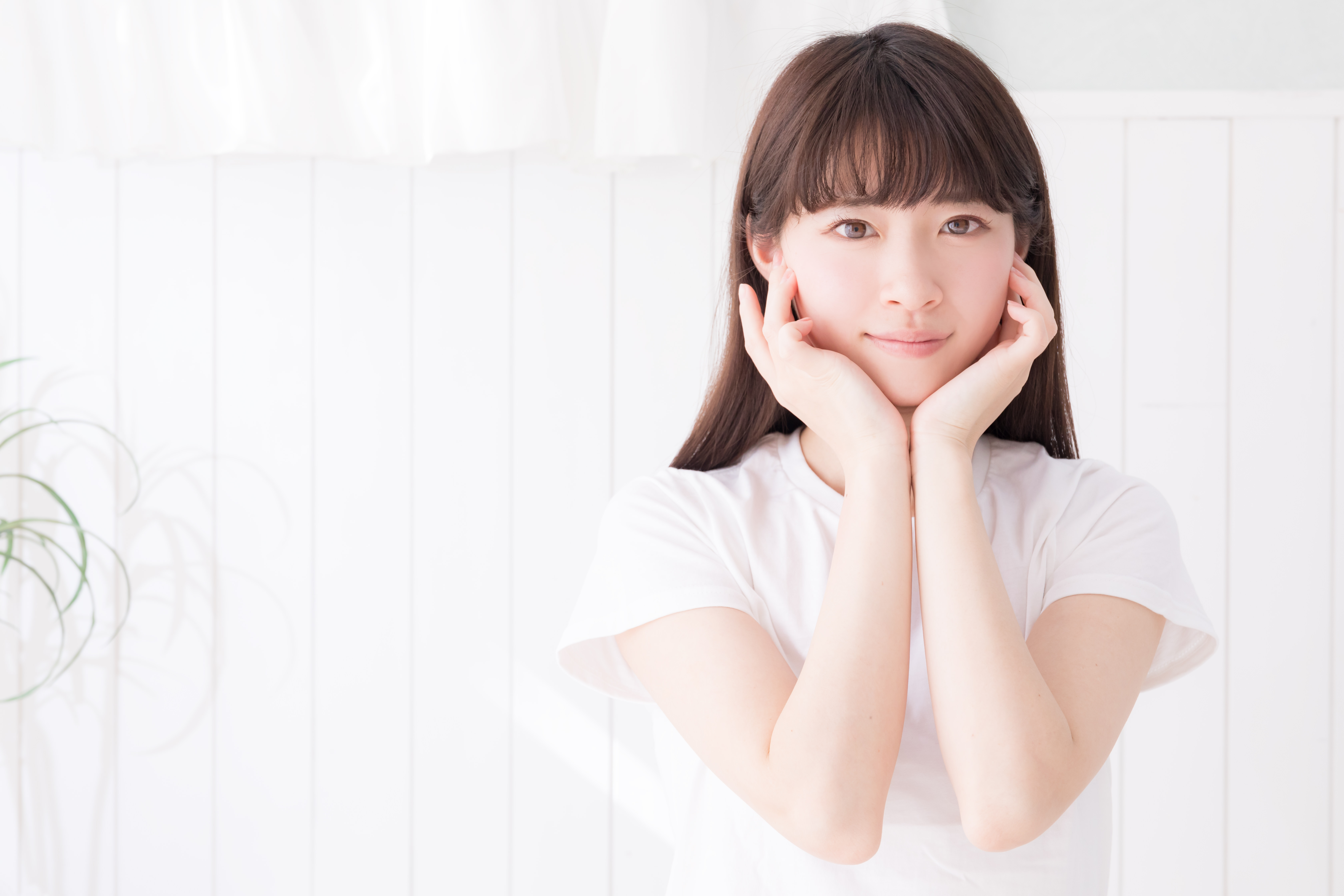白い壁の前で顎乗せポーズする女性の写真素材 ぱくたそ