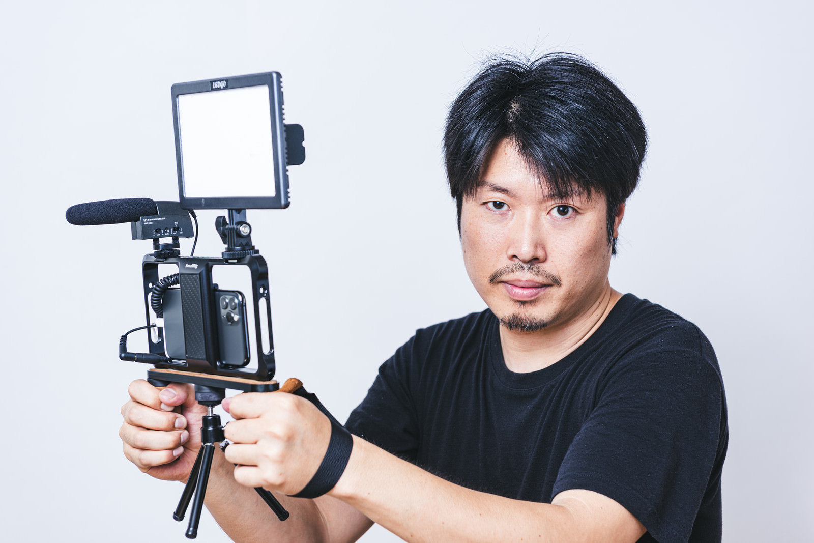 「スマートフォンでムービー撮影をする男性カメラマン | フリー素材のぱくたそ」の写真［モデル：瀧野恵太］