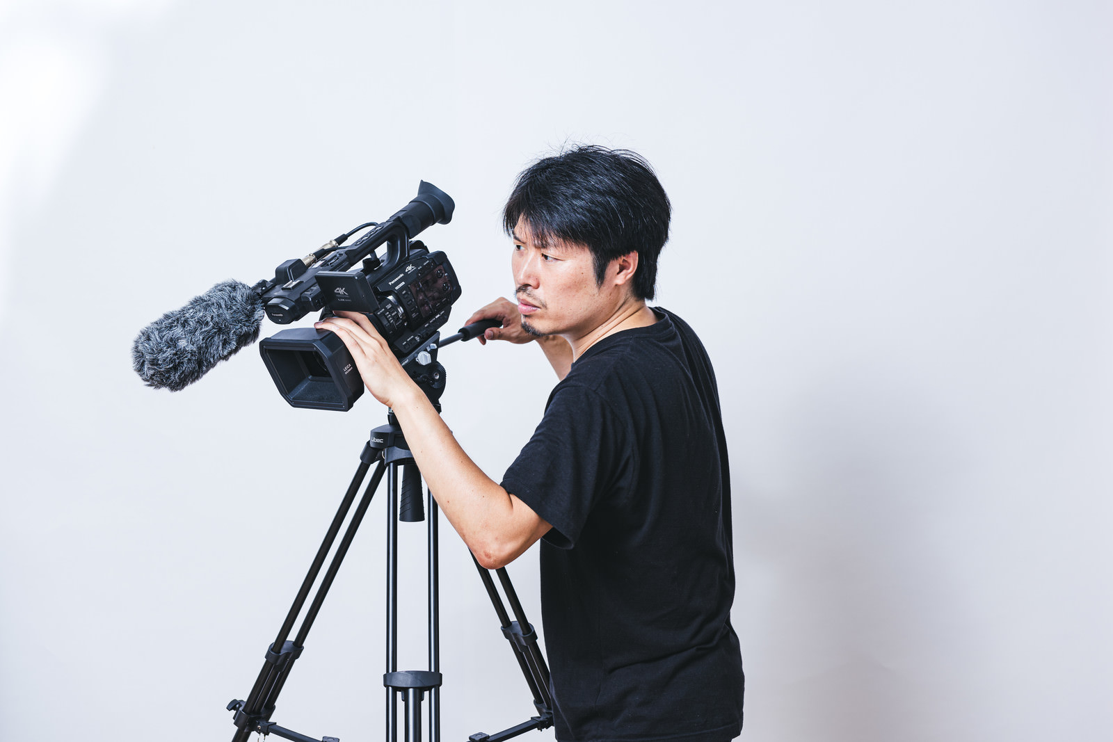 「真剣な眼差しでビデオ撮影するカメラマン | フリー素材のぱくたそ」の写真［モデル：瀧野恵太］