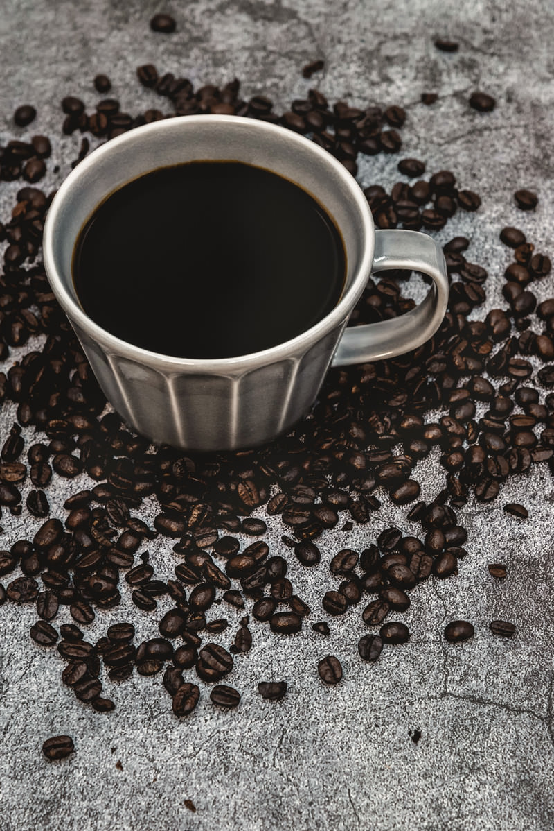 「散らばるコーヒ豆と珈琲 | フリー素材のぱくたそ」の写真