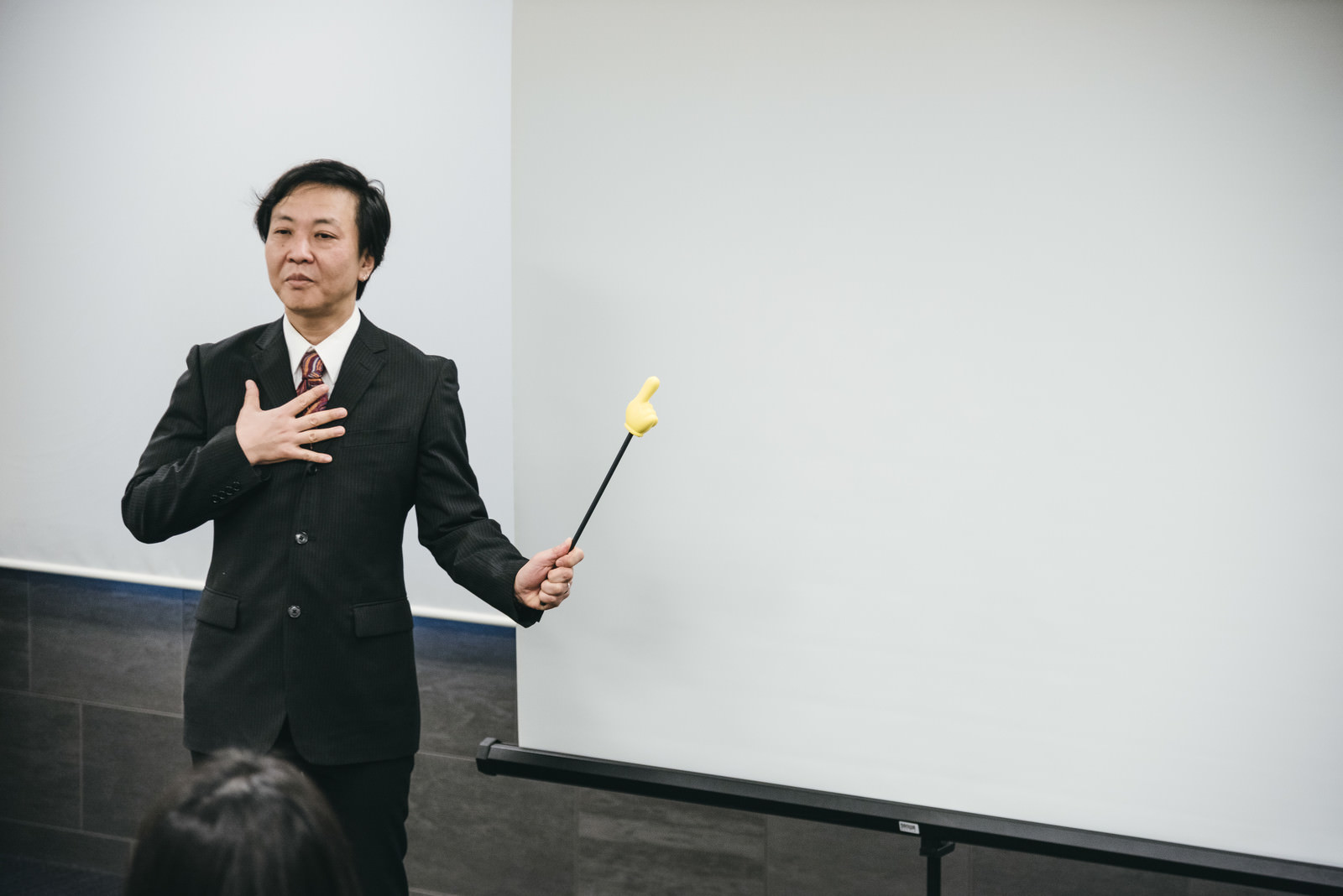 「重要なポイントだとホワイトボードを指す講師」の写真［モデル：のせさん］