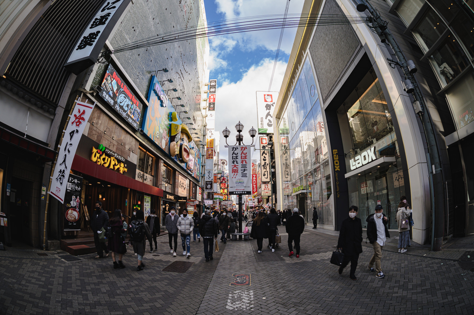 「魚眼レンズで撮る大阪ミナミを行き交う人々 | フリー素材のぱくたそ」の写真