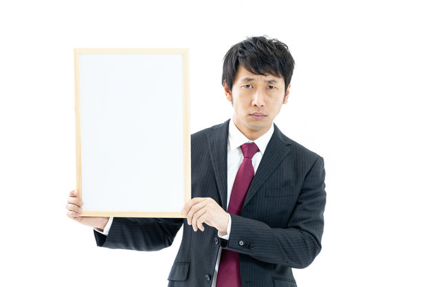 「白いフリップを持つ男性会社員」のフリー写真素材