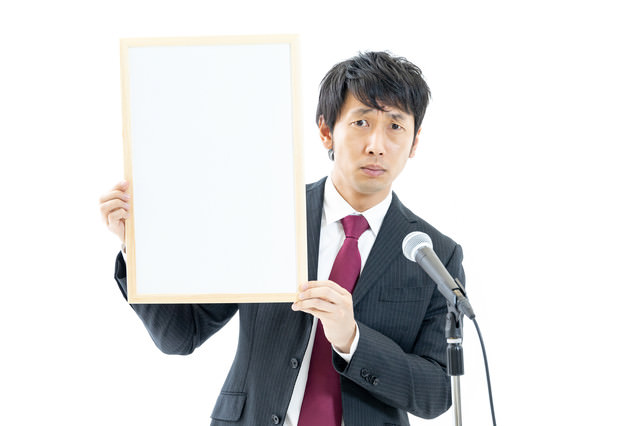 「記者の質問に顔がこわばる政治家」のフリー写真素材