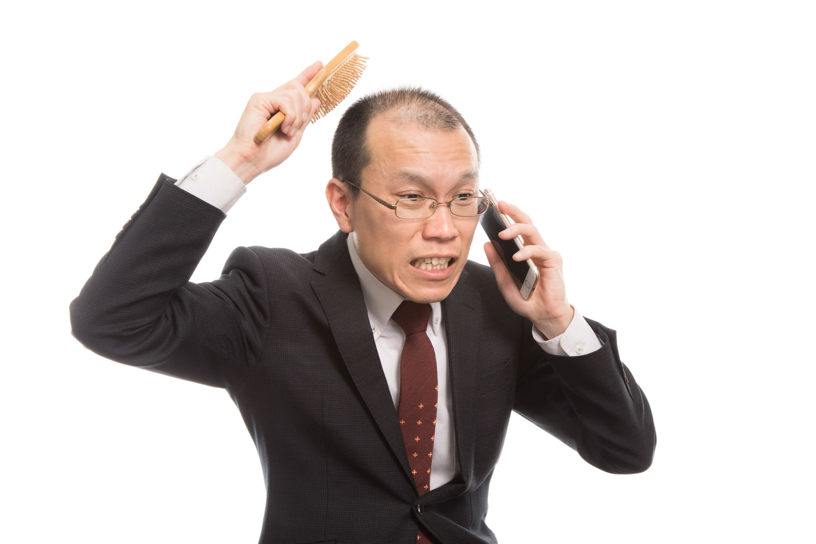 「頭頂部が薄い上司は育毛ブラシを使いながら電話する | フリー素材のぱくたそ」の写真［モデル：サンライズ鈴木］