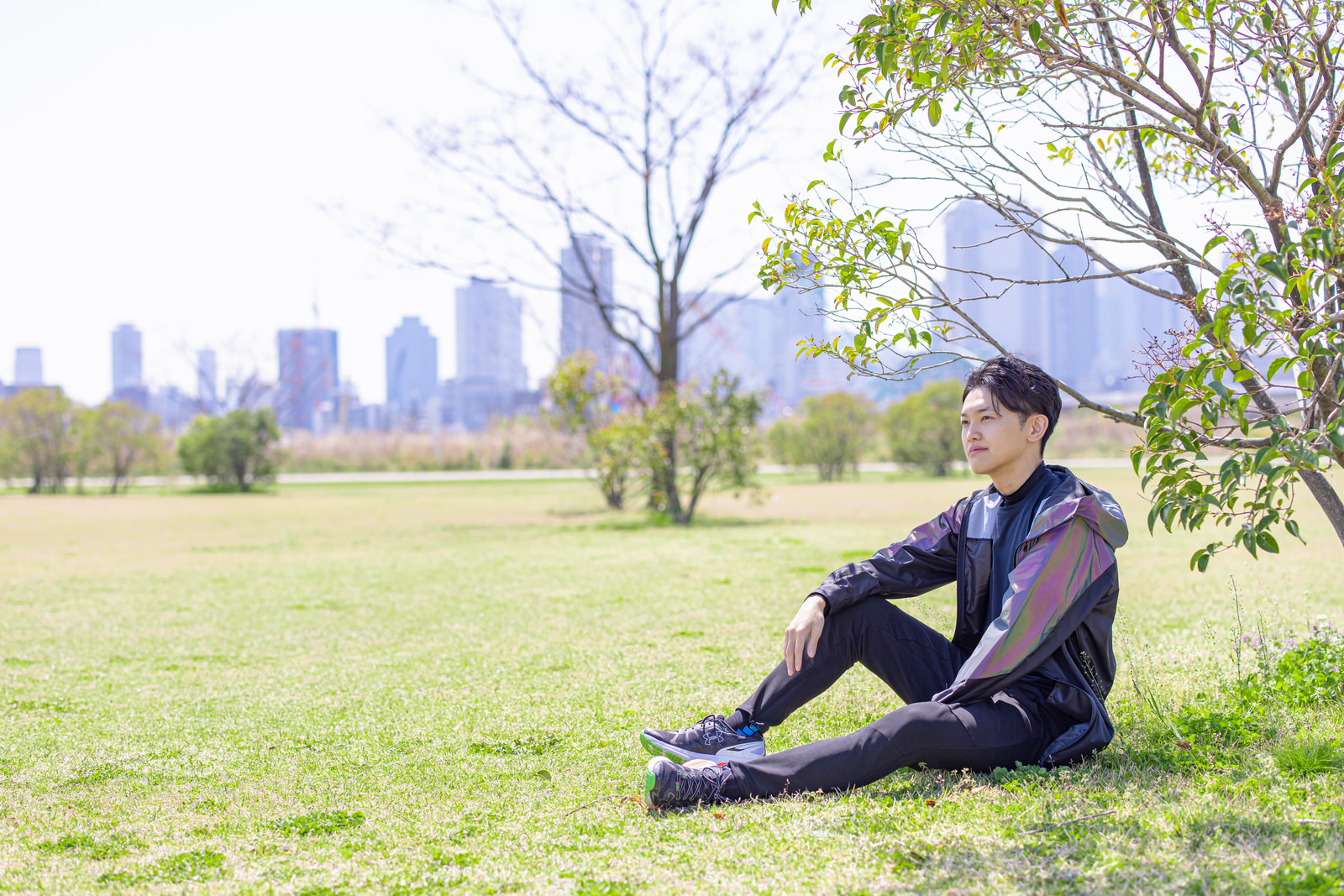 「野原で休息するランニング中の男性 | フリー素材のぱくたそ」の写真［モデル：花和瞭］