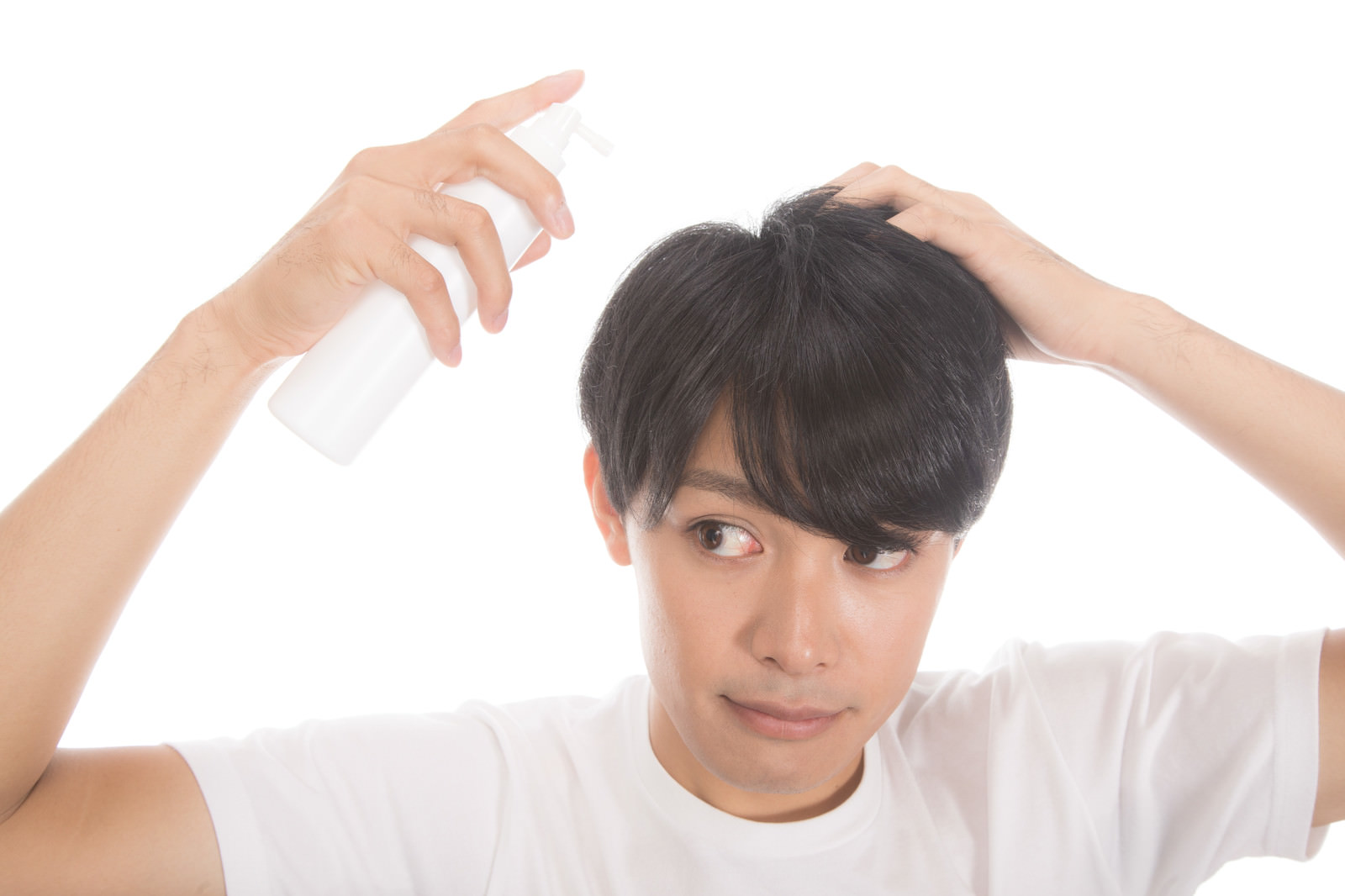 「増毛スプレーを使う若い男性」の写真［モデル：完伍］