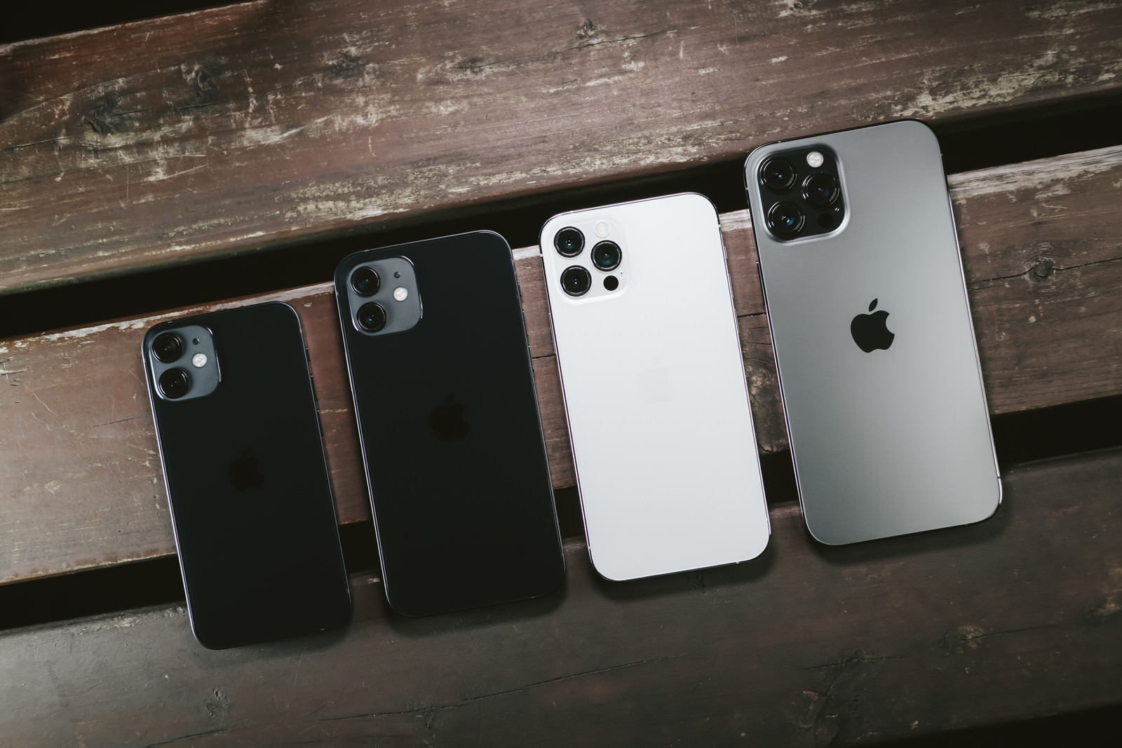 「木目板の上に並べられた iPhone 12 シリーズ | フリー素材のぱくたそ」の写真