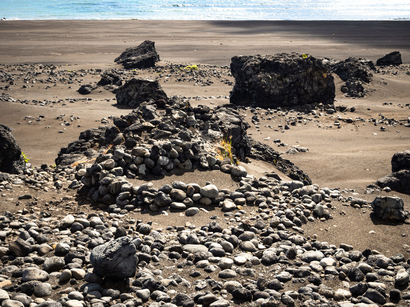 「硫黄島の砂浜の上にその姿を残す塹壕跡 | フリー素材のぱくたそ」の写真