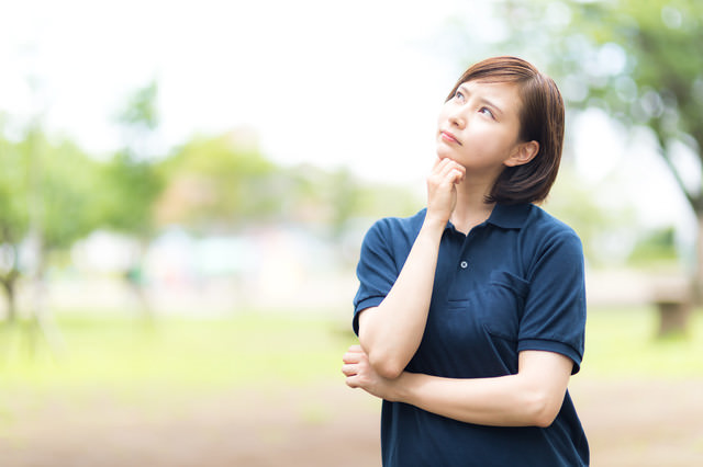 空を見上げて考え込むヘルパーの女性