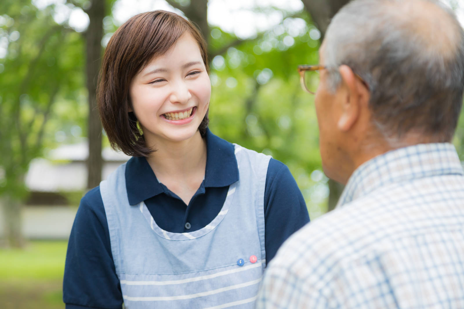 「笑顔で高齢者と接する介護士の女性」の写真［モデル：yumiko まーちゃん］