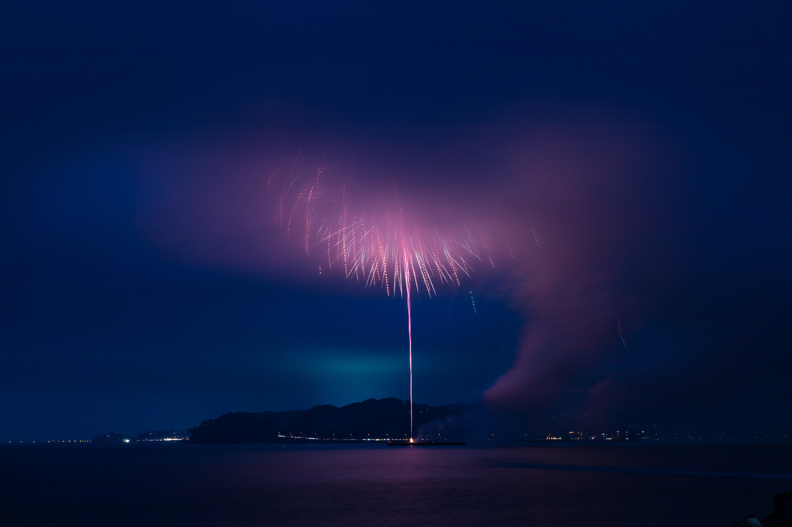 「高く打ち上がった花火が煙で見えない状態」の写真