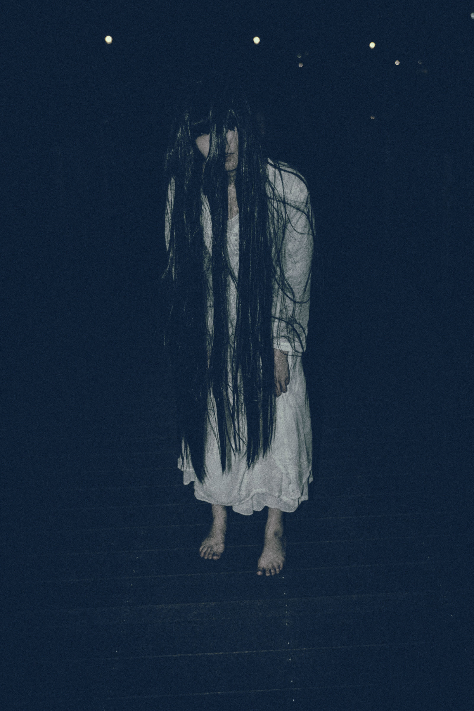 長い髪を垂れ下げてこちらに近づく女性の写真素材 ぱくたそ