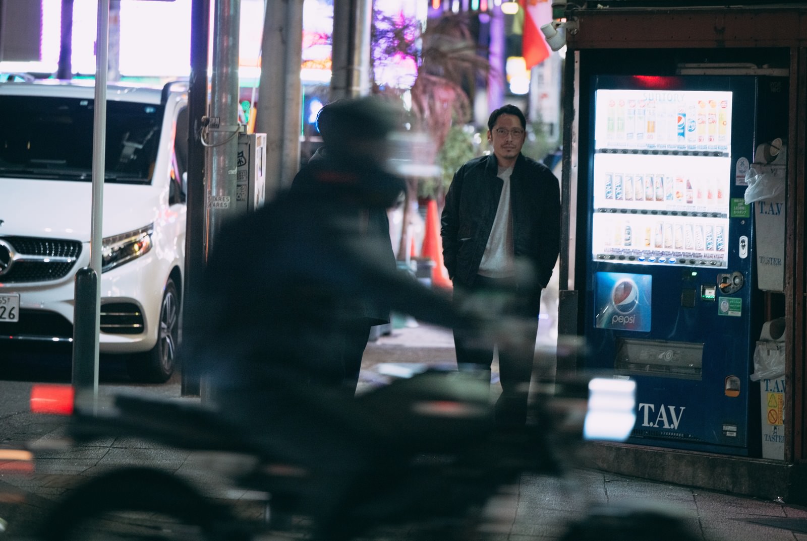 通行人を装って反対車線から尾行する男性