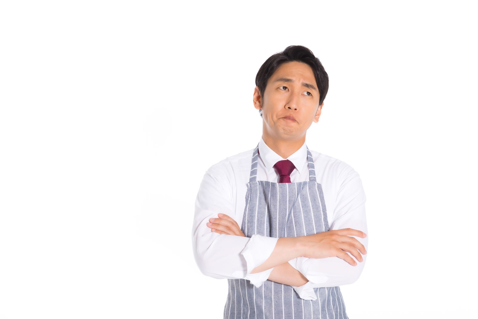 「エプロンを着用して考え込む営業マン」の写真［モデル：大川竜弥］