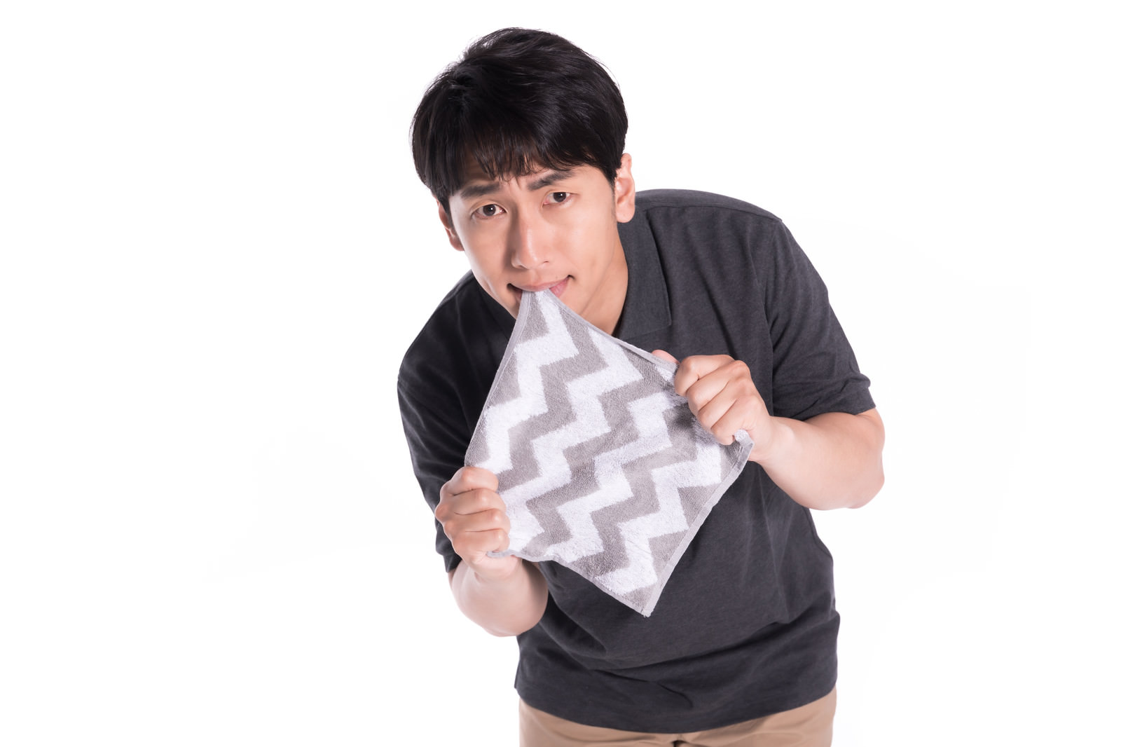「口と手でハンカチを引っ張る男性 | フリー素材のぱくたそ」の写真［モデル：大川竜弥］