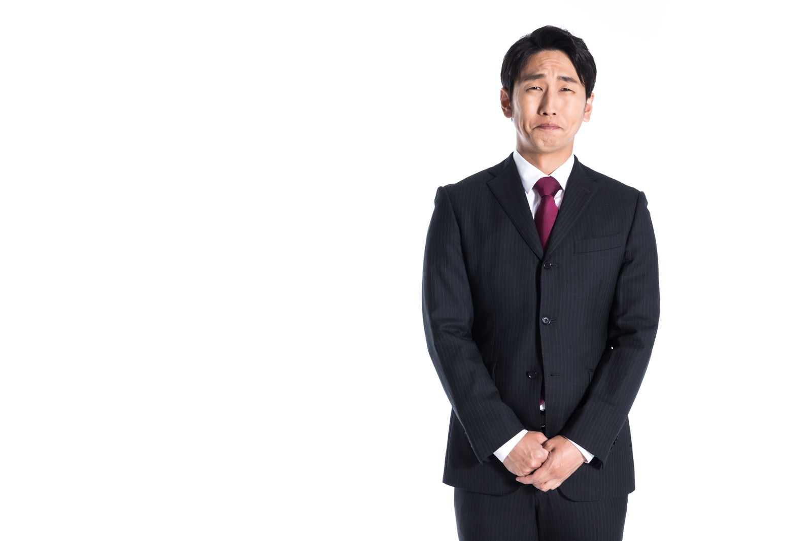 「口をつぐんでじっと我慢をする会社員」の写真［モデル：大川竜弥］