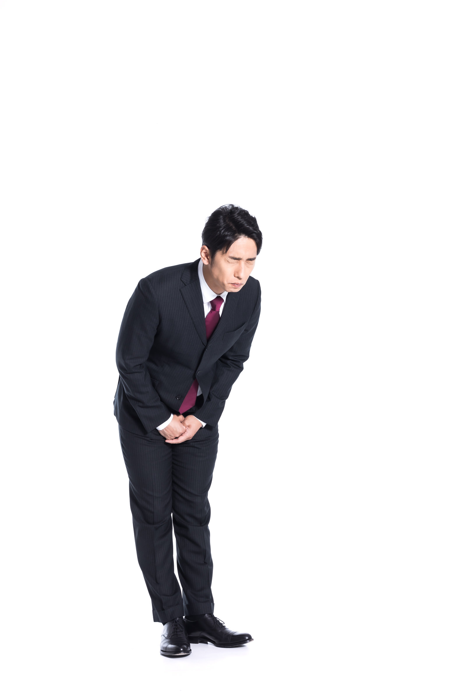 涙をこらえて謝罪をするスーツ姿の男性の写真素材 ぱくたそ