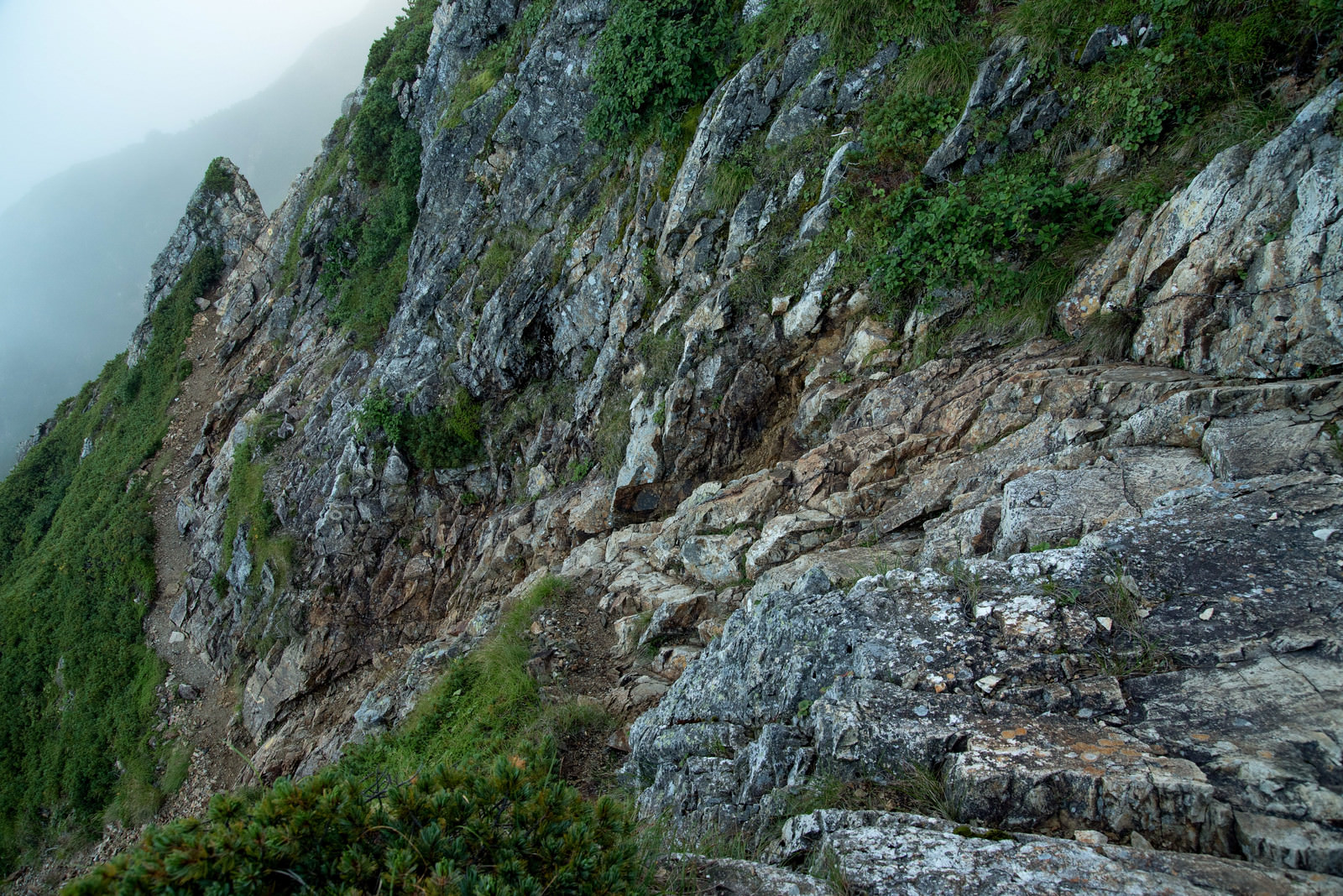 「崖沿いを進む登山道 | フリー素材のぱくたそ」の写真
