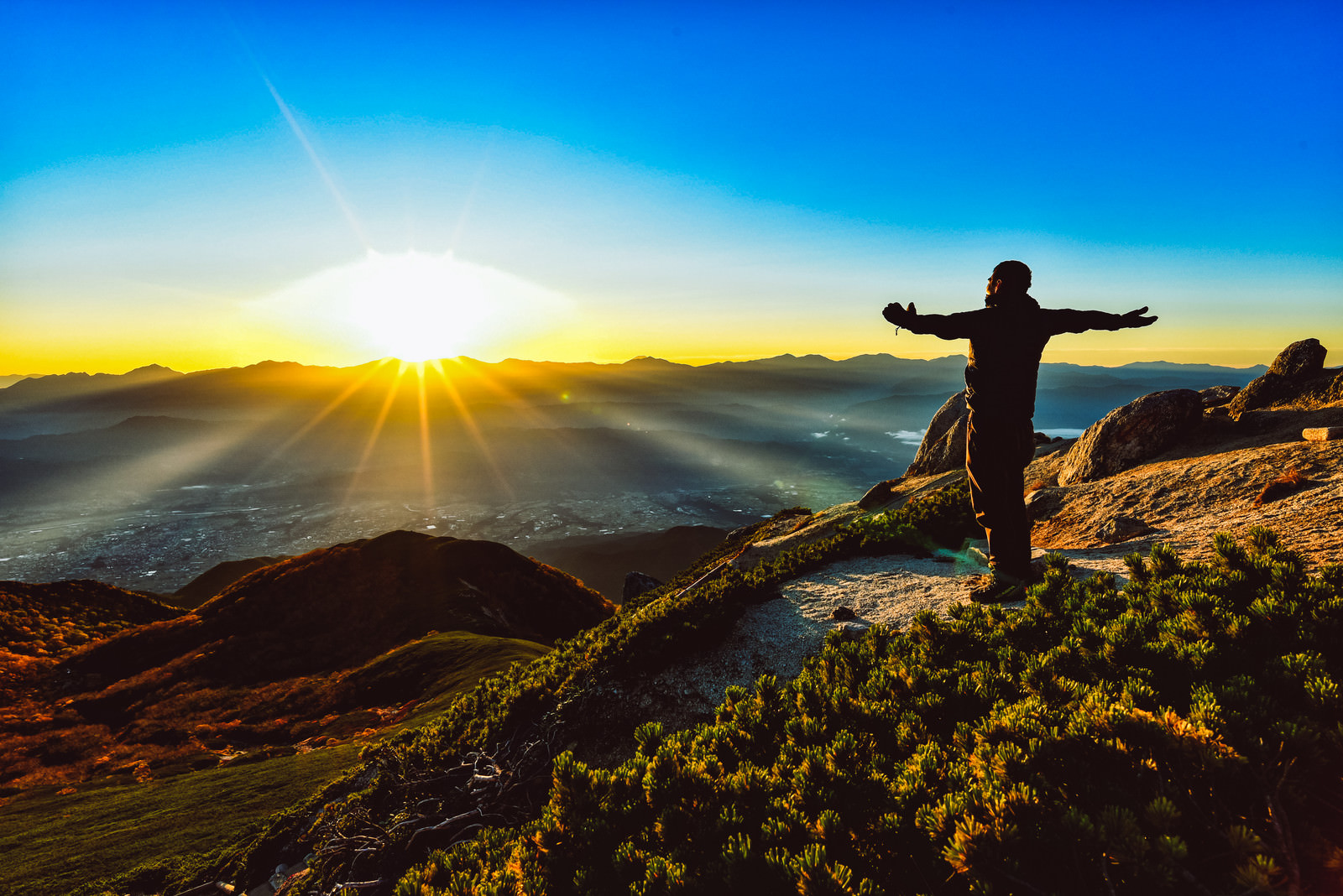 「朝日を全身に浴びる登山者」の写真