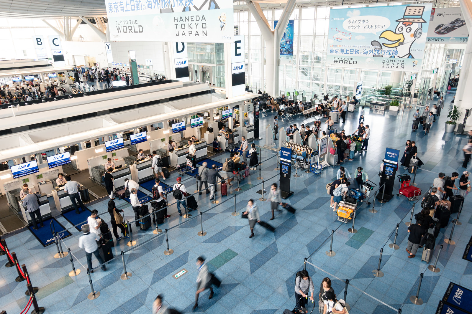 「手荷物カウンターに並ぶ人（羽田空港）」の写真