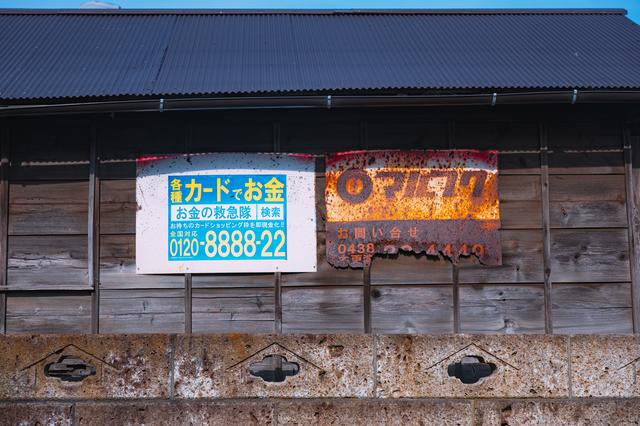 錆びて電話番号がほとんど見えなくなっている「マルフク」の看板の無料