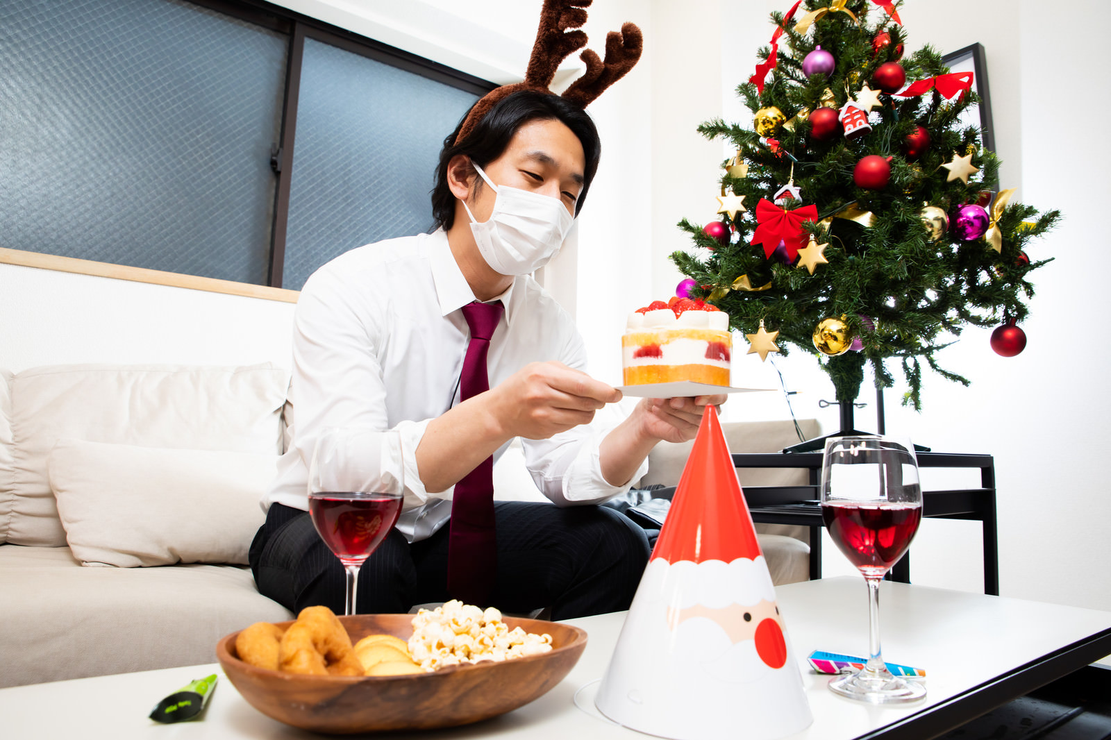 「クリスマスケーキを見つめるマスク着用の会社員 | フリー素材のぱくたそ」の写真［モデル：大川竜弥］