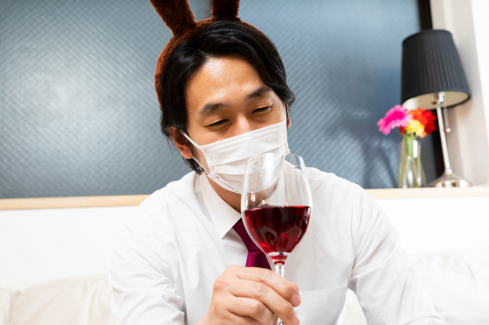 「赤ワインを飲むトナカイ男子」の写真［モデル：大川竜弥］