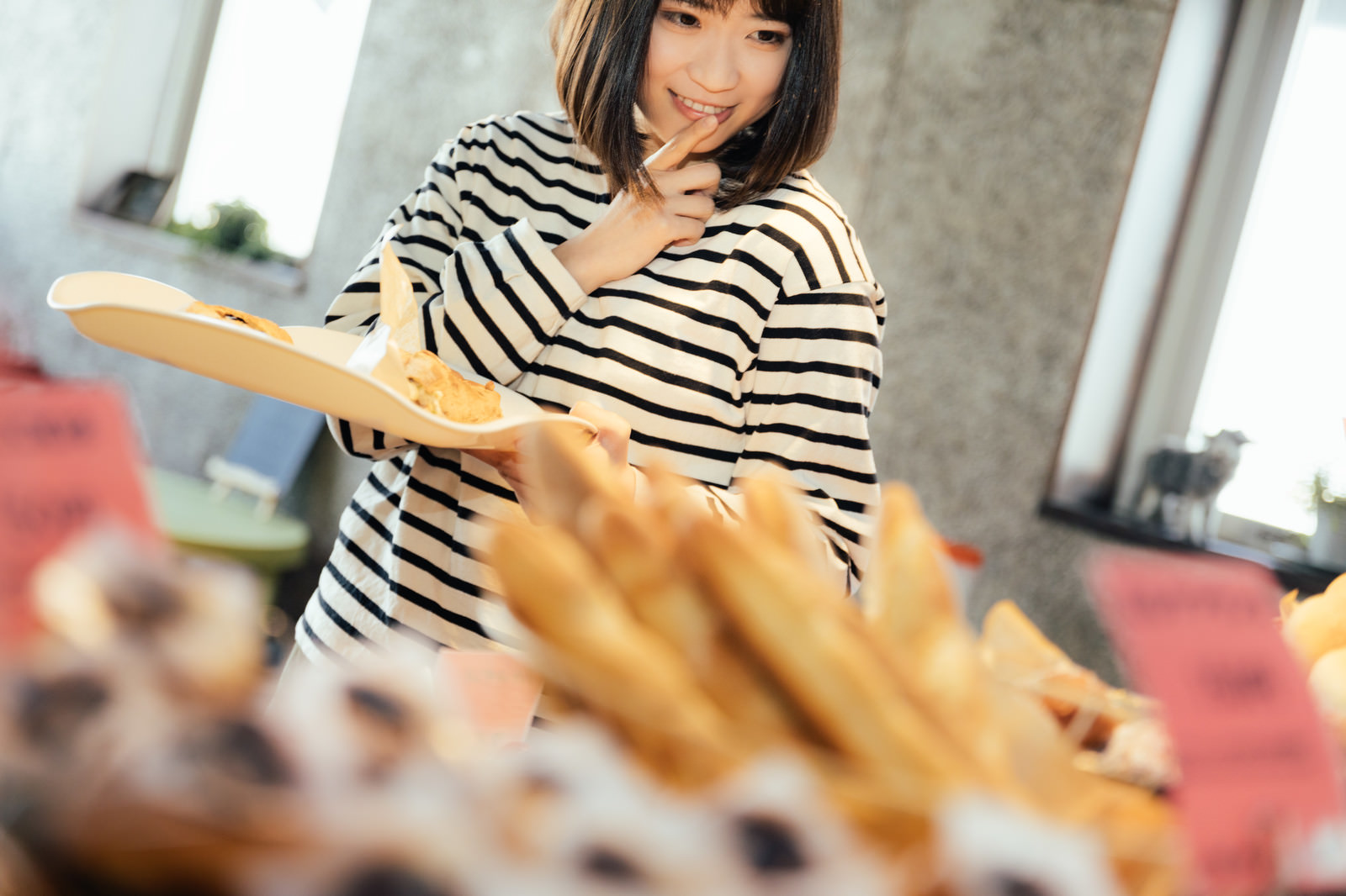 「お腹が空いたからもうひとつ食べちゃおう」の写真［モデル：塩田みう］